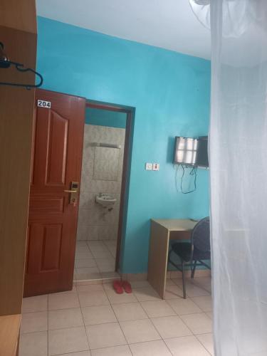 a bathroom with a toilet and a table and a door at Hummingcage in Nairobi