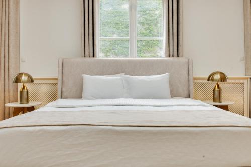 a bedroom with a large white bed with two lamps at Atik Hotel Vienna in Vienna