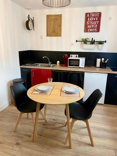 - une table et des chaises dans une cuisine avec un comptoir dans l'établissement Appartement cosy, à Quimper