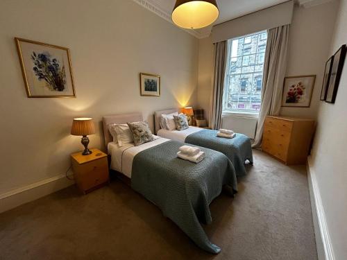 a bedroom with two beds and a window at Parliament Sq (apt 10 ) Royal Mile in Edinburgh