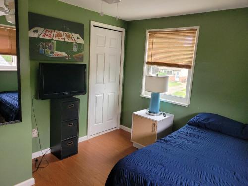 a bedroom with a bed and a flat screen tv at Cozy 6 bedroom home with Gameroom and Fire pit. in Rawsonville