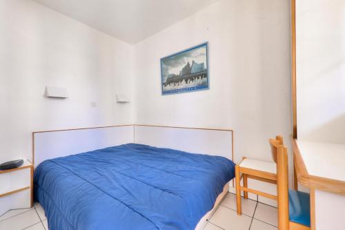 - une chambre avec un lit bleu et un bureau dans l'établissement Résidence Port du Crouesty - maeva Home - Appartement 2 pièces 4 personnes vue mer - Confort MAE-0611, à Arzon