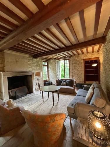 un salon avec un canapé et une cheminée dans l'établissement Charmant gîte entre Caen et la mer, à Loucelles