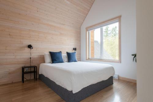a bedroom with a large bed with blue pillows at Le Chalet Waterfront Retreat in Ucluelet