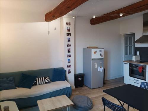- un salon avec un canapé bleu et un réfrigérateur dans l'établissement 3 bedroom city-centre apartment, à Aix-en-Provence