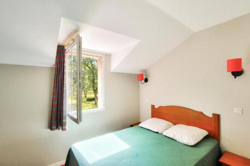 une chambre avec un lit et une fenêtre dans l'établissement La résidence du Lac - maeva Home - Maison 3 pièces 6 personnes - Sélection MAE-9501, à Monflanquin