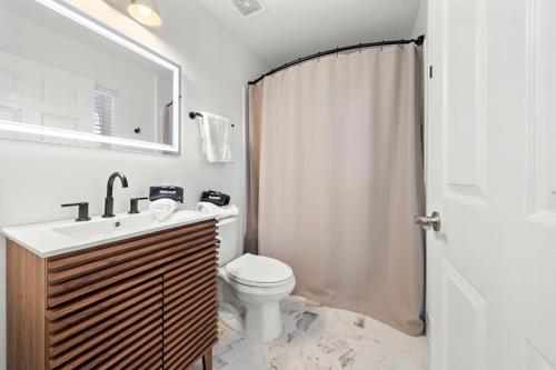 Un baño con inodoro, lavabo y ducha. en The King's Retreat I, en Houston