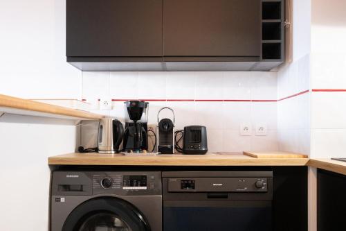 une cuisine avec un lave-linge et un micro-ondes dans l'établissement Le Rubens - Appartement 2 chambres - 6 personnes - Parking - Métro, à Toulouse