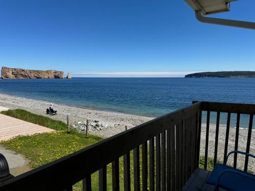 a view of the beach from the balcony of a house at Hotel-Motel Fleur de Lys in Perce