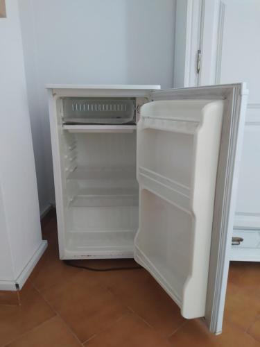 un frigorifero vuoto con la porta aperta in una cucina di Casa Pereira a Vila Nova de Milfontes