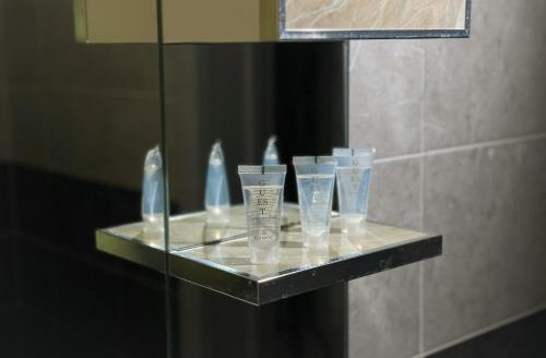ein Regal in einem Badezimmer mit vier Gläsern darauf in der Unterkunft Qafqaz Mountain Chalet in Qəbələ