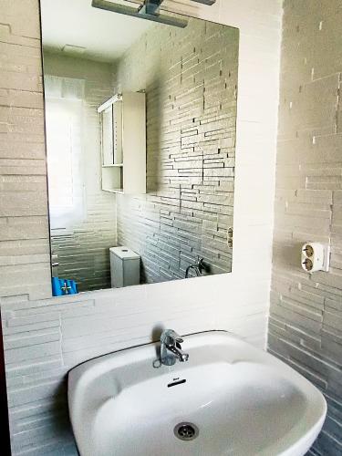 a white sink in a bathroom with a mirror at Carlys House - Calzada de Ponga 5 in Cangas de Onís