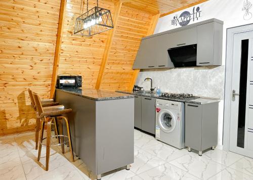 a kitchen with a stove and a washing machine at Area36 Family Chalet in Gabala