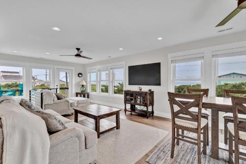 un salon avec un canapé et une table dans l'établissement Oceanwatch Cottage, à Surf City