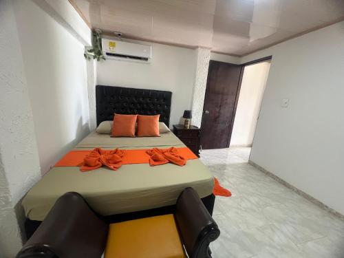 a bedroom with a bed with orange pillows on it at Posada Ashanty in Providencia