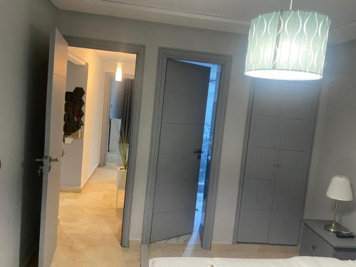 a room with a hallway with a door and a lamp at Marina Saidia Luxury Apartment with Pool & Garden View,Residence Tamaris in Saidia 