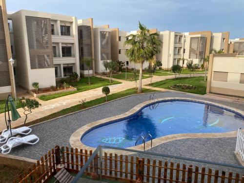 ein Schwimmbad in der Mitte eines Gebäudes in der Unterkunft Marina Saidia Luxury Apartment with pool & Garden view. Residence Tamaris in Saidia 