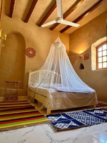 a bed in a room with a mosquito net at Desert Rose Guesthouse in Luxor