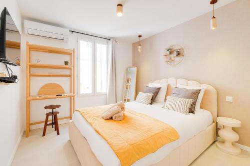 a bedroom with a large white bed in a room at Vauban, Notre Dame de la Garde, 3 chambres, terrasse, jacuzzi in Marseille