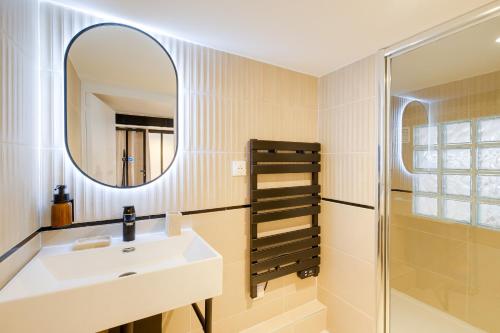 a bathroom with a sink and a mirror at Vauban, Notre Dame de la Garde, 3 chambres, terrasse, jacuzzi in Marseille