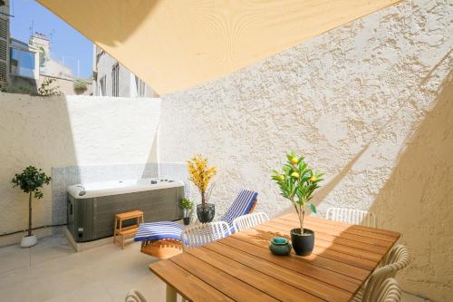 un patio avec une table en bois et un radiateur dans l'établissement Vauban, Notre Dame de la Garde, 3 chambres, terrasse, jacuzzi, à Marseille