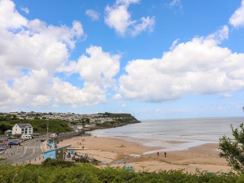 a beach with people on the sand and the water at Sandy Bay Retreat in Benllech