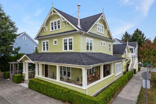 ein gelbes Haus mit einem schwarzen Dach in der Unterkunft Sea Glass Tumbler by Seabrook Hospitality in Pacific Beach