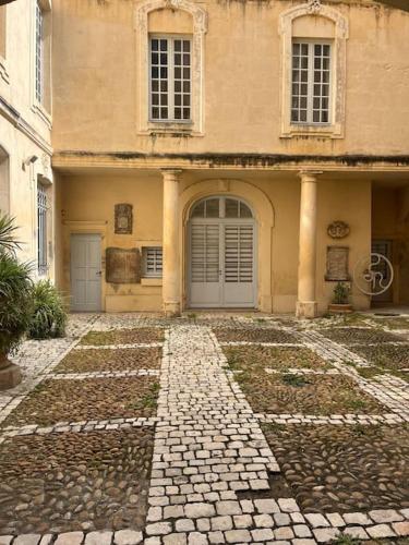 un bâtiment avec deux portes et une passerelle en pierre dans l'établissement Le Champêtre au cœur de la ville nîmoise, à Nîmes