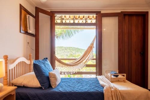 ブジオスにあるCasa em Búzios c/ Churrasqueira privativa | EDF 09のベッドと大きな窓のある寝室