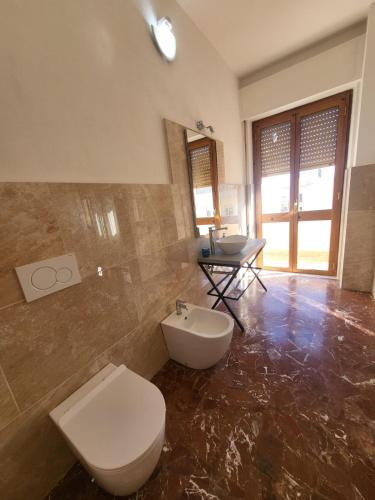 a bathroom with a toilet and a sink and a table at La camera dell’aviatore in Alghero