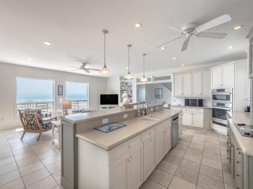 a large kitchen with white cabinets and a large island at Over The Moon in Kure Beach