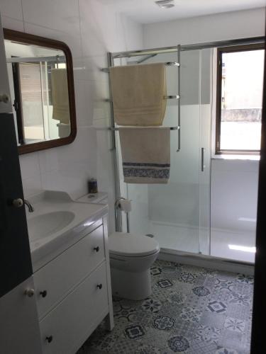 a bathroom with a toilet and a sink and a mirror at Estrela de Aver o Mar in Póvoa de Varzim