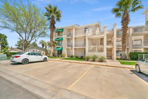 a white car parked in a parking lot in front of a building at Modern Resort Condo - Pools, Courts & Scenic Views in St. George