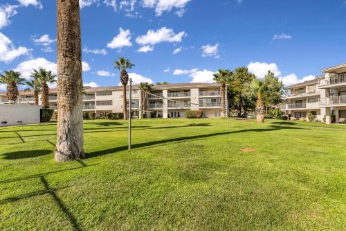 a park in front of a building with palm trees at Modern Resort Condo - Pools, Courts & Scenic Views in St. George