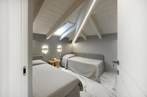 two beds in a room with white walls at Camere Amely in Sanremo