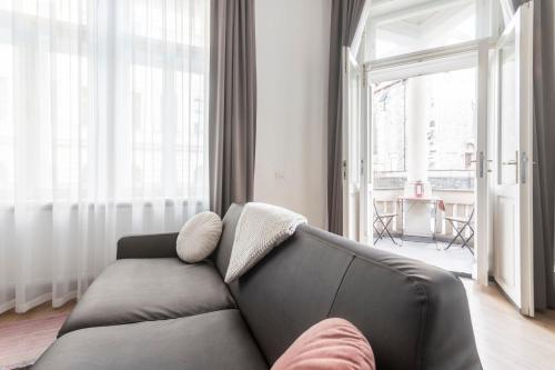 a living room with a couch and a large window at Riverside Palace Apartments in Prague