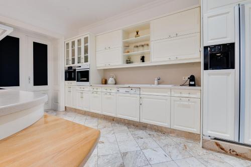 a white kitchen with white cabinets and a sink at Atik Hotel Vienna in Vienna