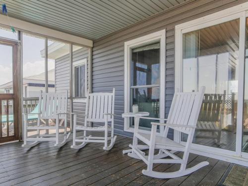 three white chairs and a table on a porch at Pana-Sea-A in Surf City