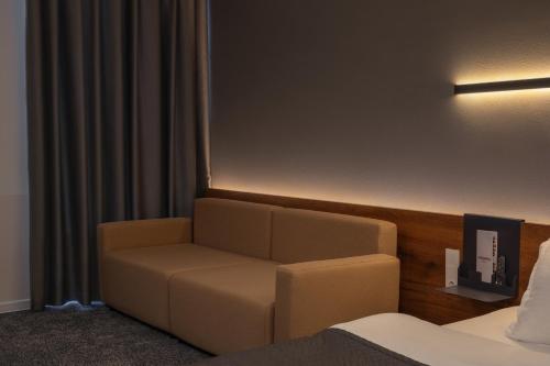 a room with a couch in a hotel room at Duo Hotel by Futuro in Bishkek