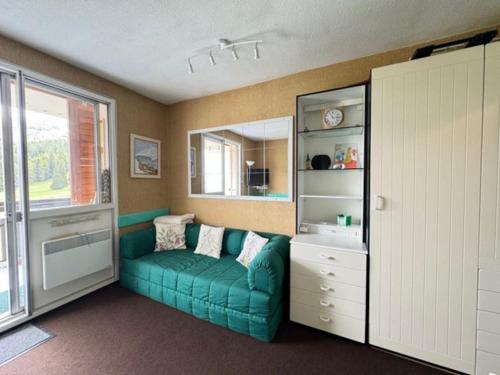 un salon avec un canapé vert et une fenêtre dans l'établissement Charmant petit Appart au pieds des pistes pour 4pers, à Saint-Étienne-en-Dévoluy