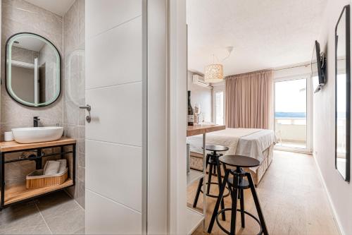 ein Bad mit einem Waschbecken und einem Spiegel im Zimmer in der Unterkunft Apartments Kartulina in Brela