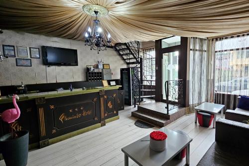 een woonkamer met een bank en een kroonluchter bij Flamingo Hotel in Piteşti