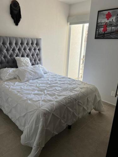 a bedroom with a large bed with a gray headboard at Departamento en zona diamante Acapulco in Acapulco