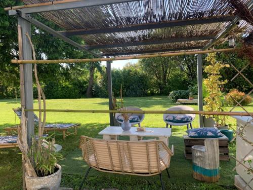 a patio with a table and chairs under a pergola at Suite privative Abella - Aile de maison bourgeoise in Ambarès-et-Lagrave