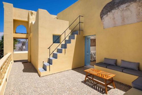 a patio of a house with a staircase and a table at Aerie 2bedroom by Thireon in Oia