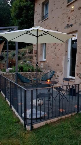 a table with chairs and an umbrella on a patio at Bed and Breakfast Tenuta delle Stelle in Seravezza