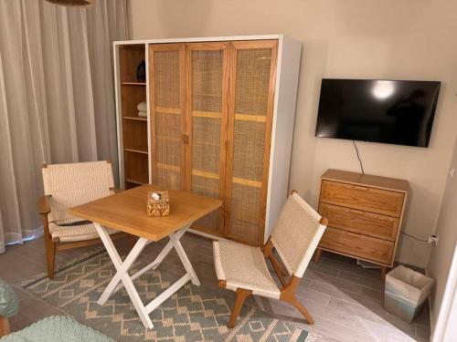 a dining room with a table and chairs and a television at Romantic Cozy Studio Bali Gouna in Hurghada