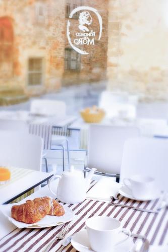 een tafel met twee kopjes en een croissant erop bij Fondaco del Moro in Civitella in Val di Chiana