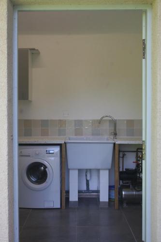 a kitchen with a sink and a washing machine at Maison L'Abeille in Saint-Plantaire
