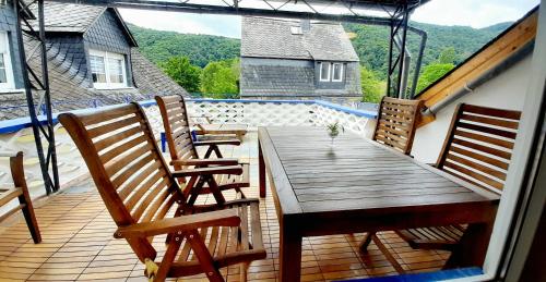a deck with a wooden table and chairs on a balcony at Blue Lagoon in Nehren